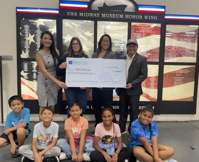 (L-R) North Island Credit Union VP, Regional Manager Therese Caballes; Leslie Houck, Zamarano Elementary School Teacher; USS Midway Director of Education Tina Chin; North Island Credit Union VP, NAS Branch Manager Dino Santos and students from Zamarano Elementary School during a check presentation to underwrite costs for 650 students from Title 1 schools to attend Midway STEM Education Onboard Field Trip experiences.
