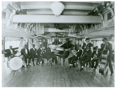 Fate Marable’s New Orleans Society Syncopators on the S.S. Sidney; Louis Armstrong and Fate Marable, fourth and fifth from left.  Circa: 1919