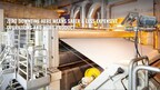 Inside of a paper mill and paper is coming off of a machine, being added to a roller with a caption stating, "Zero downtime here means safer & less expensive operations and more product."