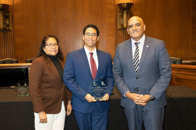 FDOT Traffic Safety Engineer Emmeth Duran, accompanied by his mother, accepts the National Roadway Safety Award from Federal Highway Administrator Shailen Bhatt.