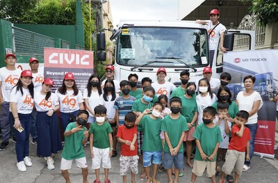Staff from UD Trucks together with children from Willing Hearts Orphanage (Philippines) posing in front of a UD Trucks’ Croner as part of UD Trucks’ “Better Life for the People” initiative to inculcate truck road safety tips, held on 25 November 2023 across Japan, Malaysia and the Philippines in collaboration with the Singapore Zoo.