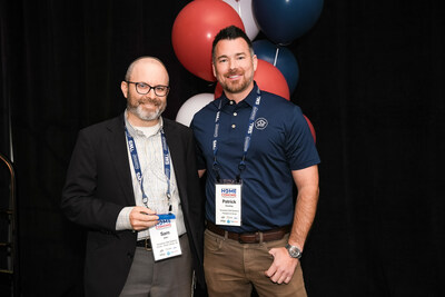 Temporary Wall Systems South Jersey owner Sam Adler, left, shows off his CARES Award trophy with Temporary Wall Systems President Patrick Kiessling, right, at HomeFront Brands' recent franchisee convention.