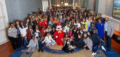Black entrepreneurs pose with Mickey Mouse at their program graduation at Walt Disney World Resort.