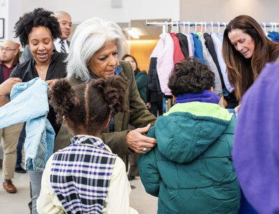 Cars for Coats: NYC Council Member Vickie Paladino helps a young New Yorker into a brand new warm winter coat to help kick-start the Greater New York Automobile Dealers Association's annual Winter Coat Drive for Kids.