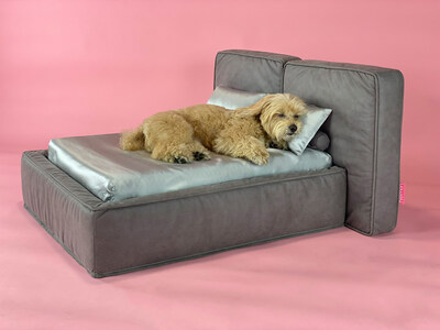 A dog sleeping soundly on Hooman's SOHO pet be in Urban Grey, curled up on luxurious grey silk sheets. Experience a new era of dog bed luxury. Discover more about the SOHO bed at thehoomanlife.com/soho.html.