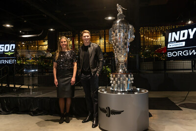 Josef Newgarden and Michelle Collins, Global Director, Marketing and Public Relations BorgWarner, pose in front of the Borg-Warner Trophy®.