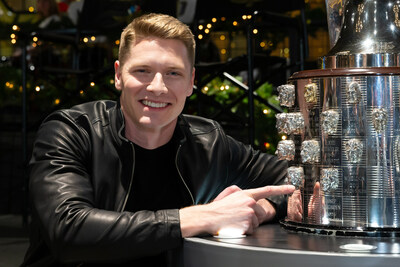 Josef Newgarden points to his newly affixed likeness on the Borg-Warner Trophy®.