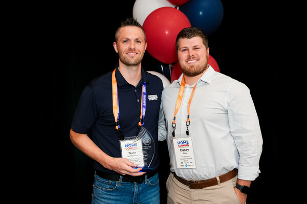 Nate Van Valkenburg, left, shows off his trophy for Top Producer of the Year for his Window Hero Charleston and The Designery Charleston locations. He is pictured with The Designery President Casey Ridley.
