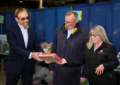 VersaBank President & CEO David Taylor (l-r), VersaBank Board Member Peter Irwin and The Salvation Army London and Community Services Executive Director Nancy Kerr look at a toy as part of a tour at a Christmas Assistance Program event in London, Ont. on Dec. 12, 2023, following a VersaBank $50,000 donation to Harvest Hope, The Salvation Army’s food security campaign. (CNW Group/VersaBank)