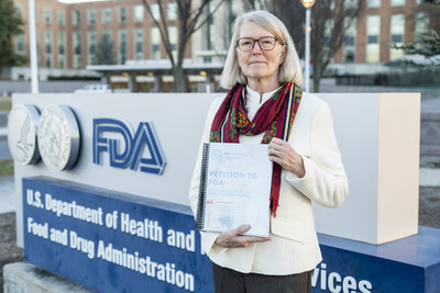 Kate McCurdy, board chair of Barth Syndrome Foundation, poses for a portrait, while holding a petition with nearly 20,000 signatures requesting the U.S. Food and Drug Administration (FDA) to review the New Drug Application (NDA) for elamipretide, the only potential treatment for Barth syndrome, at the FDA White Oak Campus in Silver Spring, Maryland, USA, on Thursday, December 21, 2023. (Barth Syndrome Foundation/Eric Lee)