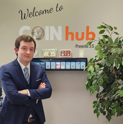 Blake Alma, the young entrepreneur and founder of CoinHub Media, stands in his Lebanon, Ohio office. With a backdrop showcasing an impressive collection of currency, Blake exemplifies the spirit of modern numismatics. Nestled in a suburb of Cincinnati, this office is where numismatic passion meets entrepreneurial vision, as hinted by the wise words of Proverbs 3:5 on the wall.