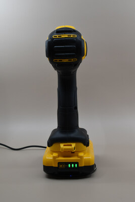 DeWalt power drill retrofitted with SmartInductive technology charges on a pad.