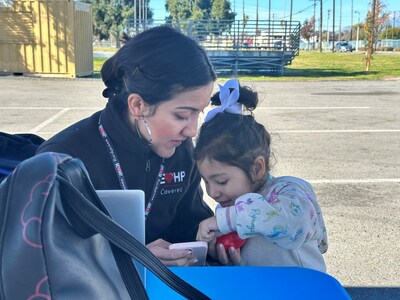Kiara Paredes, an IEHP Covered enrollment specialist, interacts with Lala Cruz, 3 of San Bernardino, during a special Covered California enrollment event hosted by the health care exchange and Colton-based Arrowhead Regional Medical Center.