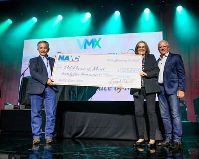 NAVC Board President, Bob Lester, DVM, presents the 2024 NAVC Gives Marquee Award to Pet Peace of Mind President Dianne McGill at the annual VMX Awards Night event January 15