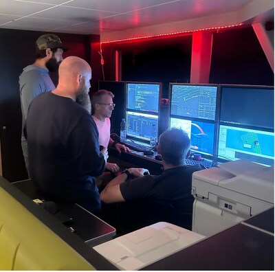 Team gathers around for review of data returning from sonar system when the system returns to the surface. Due to the amount of data collected a thorough review of all the sea floor imagery can take days to complete. (PRNewsfoto/Deep Sea Vision)