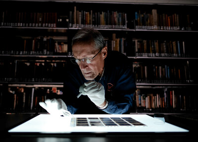 John Warton of Revs Institute inspects a selection of negatives from the André Van Bever collection. (Credit: Revs Institute)