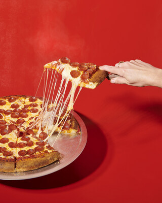 Hand pulling a slice from a Village Square Pizza pepperoni & cheese pizza