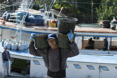 Baskets of Aa being carried off the boat by a SAMBAZON employee