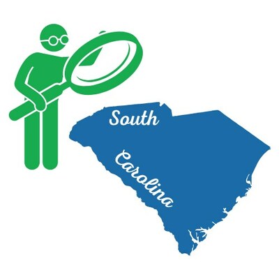 Person with magnifying glass looking at state outline of South Carolina.