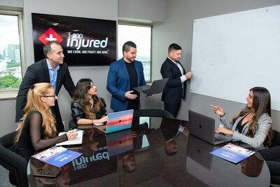 The team at 1-800-INJURED, meeting in an office room