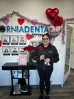 A delighted patient at the South Gate office expresses joy upon receiving a rose during her dental visit.