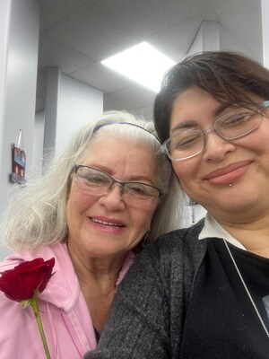 A patient and a staff member at the Whittier office share smiles, both delighted by the rose the patient received during her dental visit.