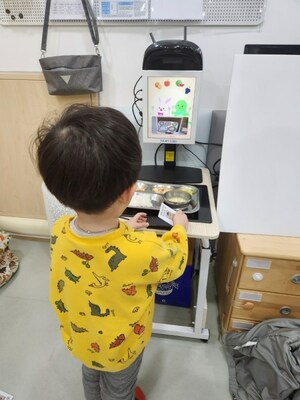 A child scanning his tray with Nuvilab's AI Food Scanner at a Childcare Center in Jongno District