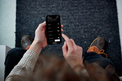A top-down view over the shoulders of a man using the Terra Kaffe app on his phone. His app displays the settings for an Espresso Profile.