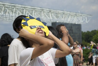 A visitor views a solar eclipse from the National Air and Space Museum's Steven F. Udvar-Hazy Center in 2017.