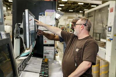 Two of 350 Michigan-based Pollard Banknote employees operating the TRESU press (CNW Group/Pollard Banknote Limited)