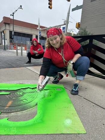 Humans in a half-shell painted ooze on top of manholes to represent Teenage Mutant Ninja Turtles departure from the sewers for their arrival at The Children's Museum of Indianapolis