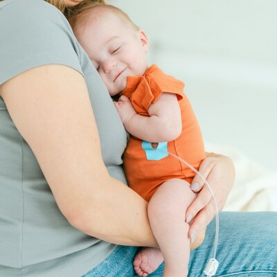 Baby wearing Tabeeze Rust Bottom-Up Bodysuit with Blue Tube-eeze Patch