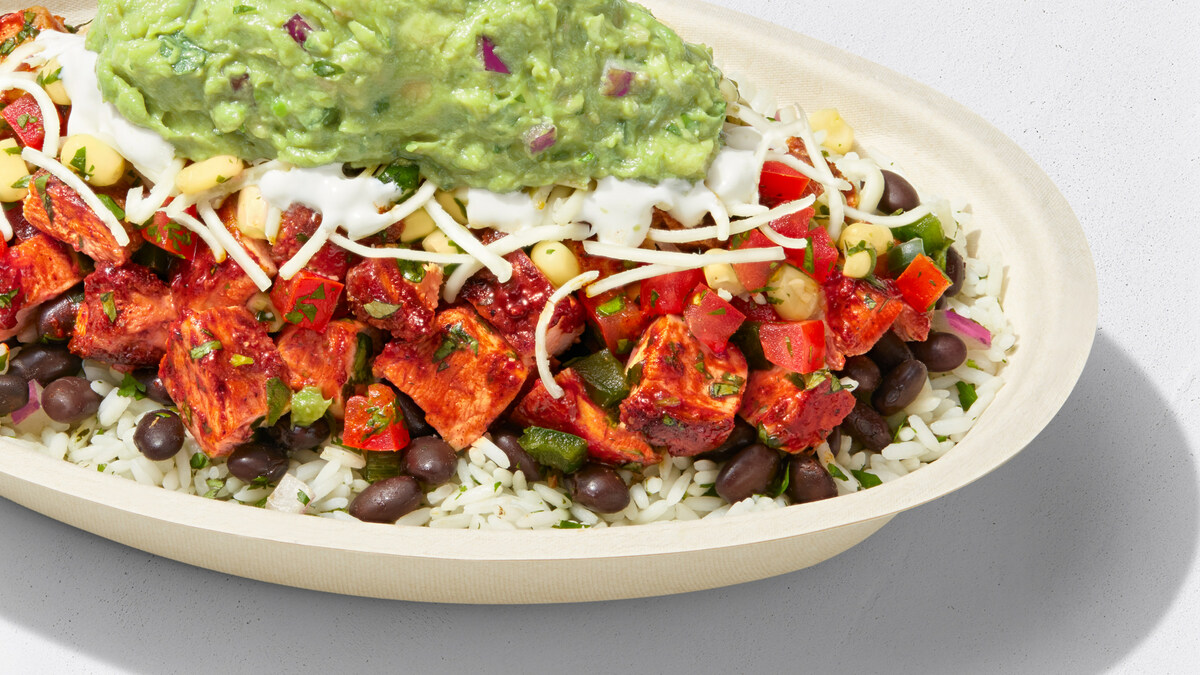 Chipotle burrito bowl with rice, black beans, chicken, salsa, cheese, corn and guacamole
