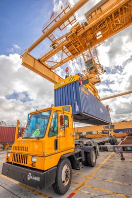 The Port of Huntsville gantry crane places a container on a truck chassis.