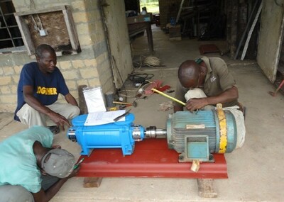 Local technicians prepare to install a new pump solution for water delivery.