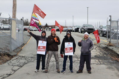 CN Autoport workers stand on the picket line holding Unifor flags (CNW Group/Unifor)