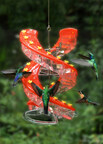 Cascade flagship DNA Hummingbird Feeder with red cover and 32 yellow flower-shaped ports hangs with 5 hummingbirds feeding at different ports.