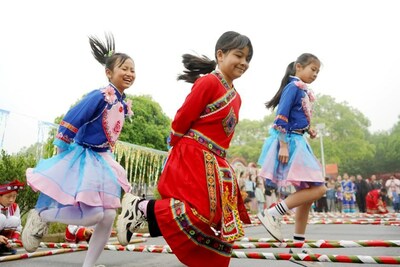 Foto tirada em 13 de abril de 2024 mostra que três meninas da vila de Yanglin estão dançando em longas varas de bambu. (Foto de Chen Qihai) (PRNewsfoto/Xinhua Silk Road)