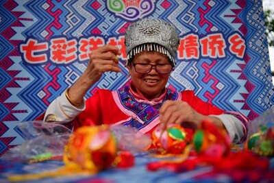 La fotografía tomada el 13 de abril de 2024 muestra a un aldeano de Yanglin haciendo una bolsa china para perfume. (Fotografía de Shi Yu) (PRNewsfoto/Xinhua Silk Road)