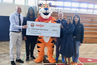 Battle Creek Public Schools received a $50,000 donation from WK Kellogg Co and Meijer through Kellogg's Frosted Flakes Mission Tigertm. From L to R: Lorin Granger, athletic director for Battle Creek Public Schools; Donovan Edwards, running back for University of Michigan football team; Tony the Tiger; Doug VanDeVelde, chief growth officer for WK Kellogg Co; Dr. Kim Carter, superintendent for Battle Creek Public Schools; Kaylee Schultz, Meijer Director of Merchandising for Dry Grocery