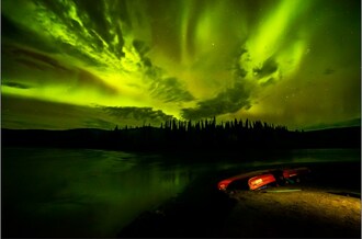 Légende : Des aurores boréales surplombant le confluent des rivières Peel et Snake dans le bassin hydrographique Peel. 
Photo : Tayu Hayward (Groupe CNW/Parcs Canada (HQ))