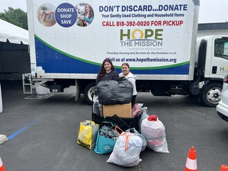 Rooter Hero Social Media Coordinator Katherine Conchas, left, and Hero Helps Coordinator Magda Elizondo pose with the boxes and bags of clothing donated by Rooter Hero employees to Hope the Mission to be sold in the mission's thrift stores.