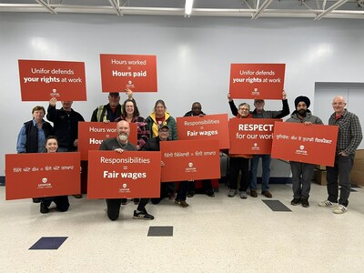 A group of people holding signs that call for fair wages. (CNW Group/Unifor)