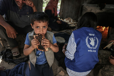 A young boy eats bread from WFP in Gaza, where more than 1 million people face catastrophic hunger. Photo credit:  WFP/Ali Jadallah