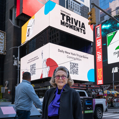 Barbaralee Diamonstein-Spielvogel, chair of The Historic Landmarks Preservation Center and the NYC Landmarks60 Alliance, stands proudly in Times Square with the pre-promotion content of the Trivia Moments campaign as her backdrop.
