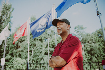 Man standing in front of flags