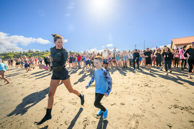 EB Research Partnership Co-Founder, Jill Vedder, leads the Plunge for Elodie in Seattle alongside Patterson, a young boy living with Epidermolysis Bullosa (EB). Photo by Tim Durkan