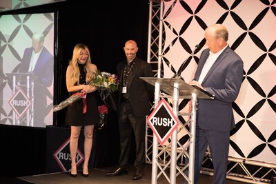 William Chivers congratulates Reuben (Ben) Thornton, along with his wife, Diana Thornton, on the promotion from the stage at RUSH's 40th Anniversary celebration on May 4, 2024.