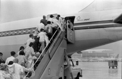 Refugees board first flight of CF707 Hong Kong to Canada, 1979. Photograph attributed to MCpl Bryantowich. 
 Canada. Department of National Defence / Library and Archives Canada / e999901766-u (CNW Group/Parks Canada (HQ))