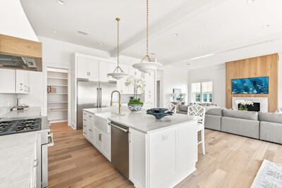 The gourmet kitchen and adjacent living room provide an excellent gathering venue for family and friends. The lofted ceilings and bright, light-filled interiors shown here are hallmarks of the property's design. OceansideLuxuryAuction.com.